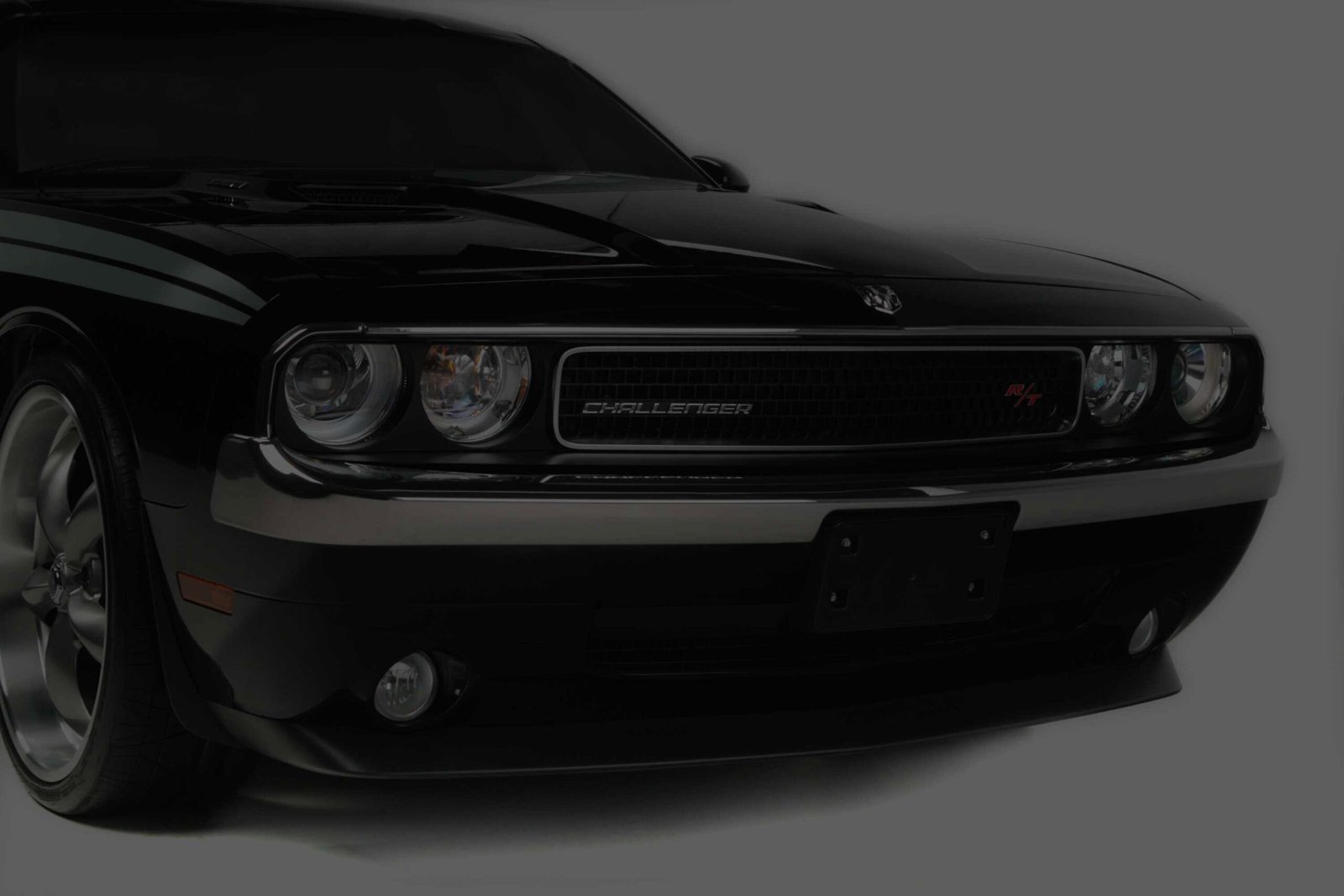 Front of a black Dodge Challenger with a chrome grille and headlights